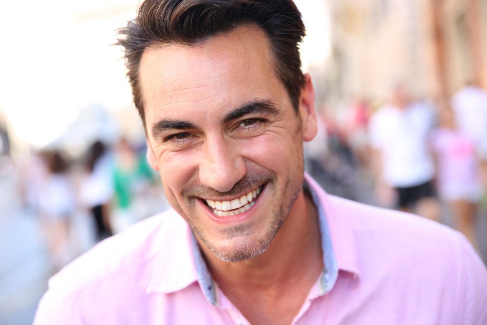 Laughing man in pink collared shirt