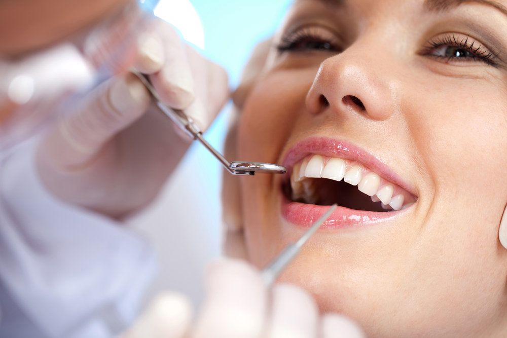 Smiling woman undergoing dental exam